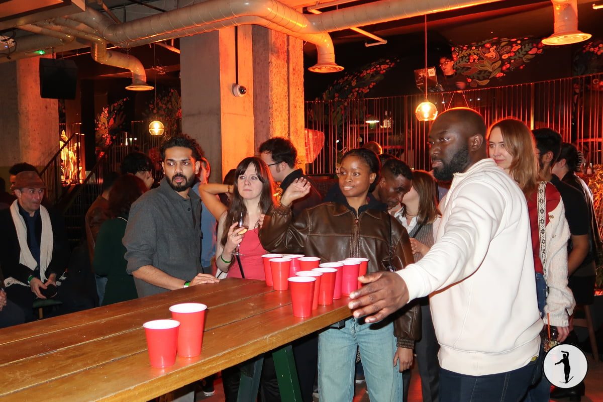 Guests playing beer pong around a table at a Balancers evening