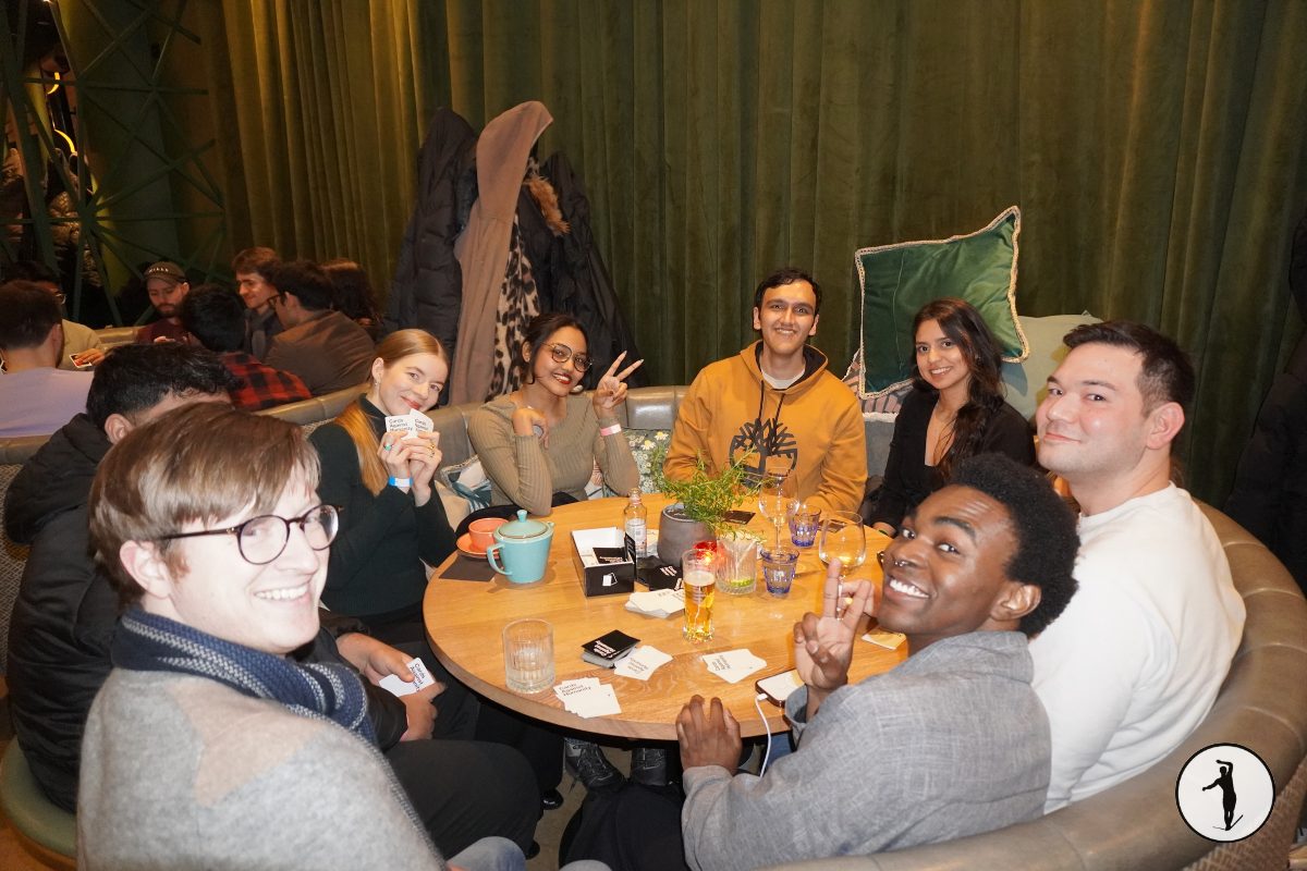 Guests seated around a table playing cards at a Balancers evening