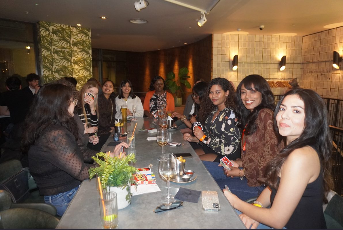 Women seated around a table playing cards during Wine Not by Balancers